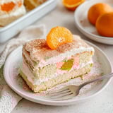 Ein Stück Kuchen mit einer Orange auf dem Deckel.