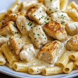 Eine Platte mit Pasta, Chicken und Zwiebeln.
