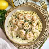 Ein Bogen Pasta mit Shrimp und Zwiebeln auf einem weißen Teller.
