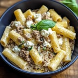 Ein schwarzes, leeres Bowl mit Pasta und Käse.