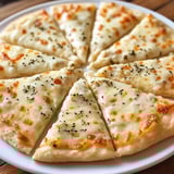 Eine Scheibe Pizza mit Käse und Kruste auf einem weißen Teller.