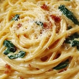 Eine Platte mit Pasta, Bacon und Spinat.
