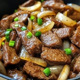 Ein Schmelztopf mit steckrigen Zwiebeln und Fleisch.