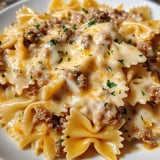 Eine Platte mit Penne-Nudeln, die mit Käse und Rindfleisch garniert sind.